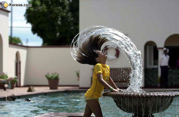 L'eau et la femme un beau mariage cheveux en mouvement avec de l'eau dans une fontaine